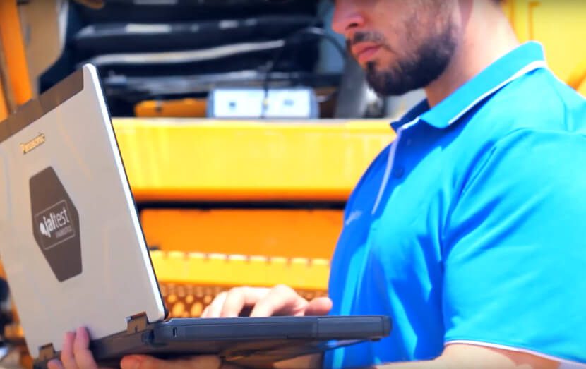 jaltest diagnostic specialist with computer next to commercial vehicle